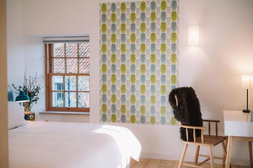 a bedroom with a bed and a chair and a window at Slackbrae in Forest Mill