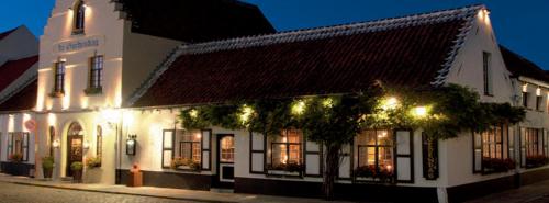 a white building with christmas lights on a street at De Goedendag in Bruges