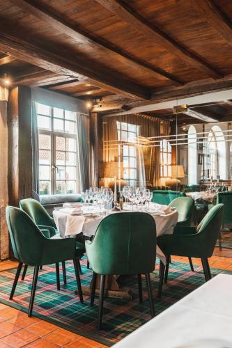 布魯日的住宿－De Goedendag，一间带桌子和绿色椅子的用餐室