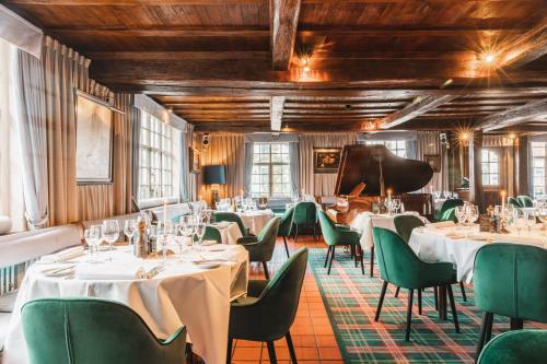 een restaurant met witte tafels en groene stoelen bij De Goedendag in Brugge