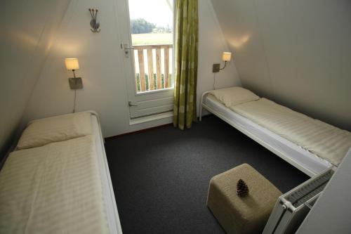 um pequeno quarto com 2 camas e uma janela em Vakantie bij Meeussen - Molendal em Plasmolen