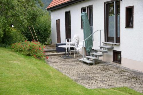 a patio with a table and chairs and a green umbrella at Ferienwohnung Dürnbach in Albstadt