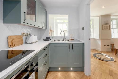 uma cozinha com armários brancos e um lavatório em Newly Renovated City Apartment em Bath