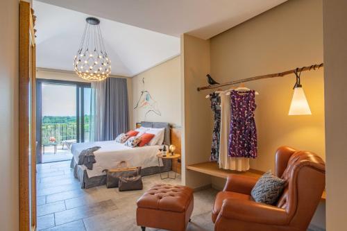 a bedroom with a bed and a chair at Braida Wine Resort in Rocchetta Tanaro