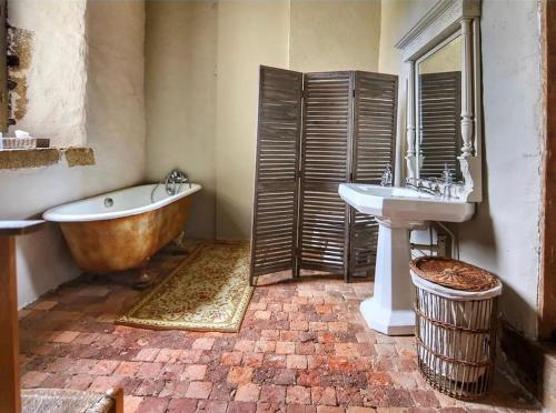 een badkamer met een bad, een wastafel en een bad bij Chateau de Bourgon in Montourtier