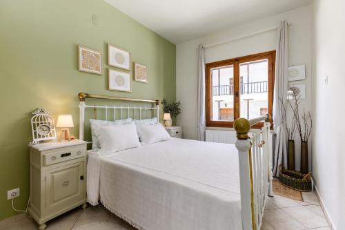 1 dormitorio con cama blanca y ventana en Villa Sevasti Platamonas Holiday Home, Panel Hospitality Homes & Villas, en Platamonas