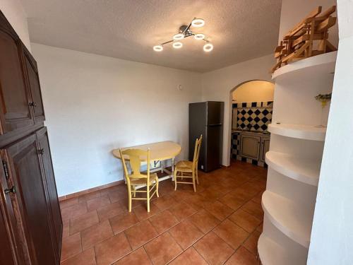 une cuisine avec une table, des chaises et un réfrigérateur dans l'établissement Grand T2 très lumineux en rez de jardin villa, à Carqueiranne