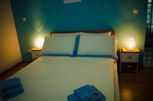 1 dormitorio con 1 cama blanca y 2 mesitas de noche en Room in Villa - The blue room is an accent of modernity in the silence of the surrounding garden, en Antananarivo