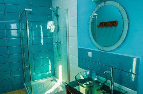 a blue bathroom with a glass sink and a shower at Room in Villa - The blue room is an accent of modernity in the silence of the surrounding garden in Antananarivo