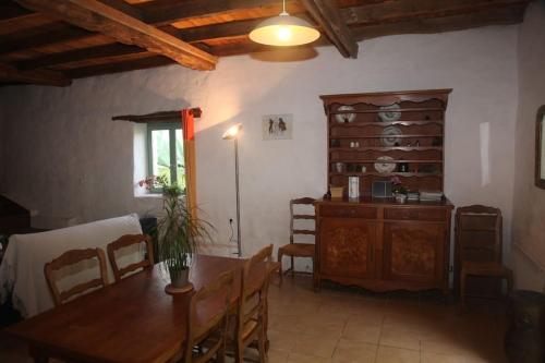 d'une salle à manger avec une table et une armoire en bois. dans l'établissement Sérénité à la ferme équestre, à Lempzours