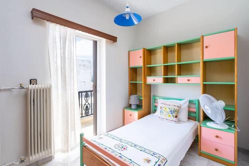 a bedroom with a bed and shelves and a window at Cozy Apartment 2 in Sitia