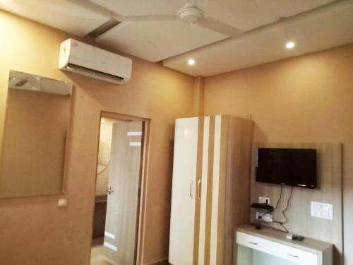a room with a refrigerator and a tv on the wall at Virat Resorts, Sariska Rajasthan in Bairāt