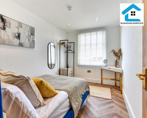 een slaapkamer met een bed en een raam bij Ideal Weekly and Short Stay with Seaview in Brighton by Bluehouse Shortlets in Brighton & Hove