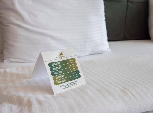 a sign sitting on top of a bed at Hilly Hotel in Edirne