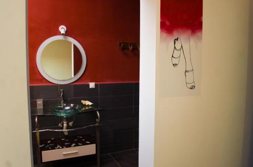 een badkamer met een wastafel en een spiegel bij Room in Villa - The romantic atmosphere of the red room to discover the pleasure of a stay in Antananarivo