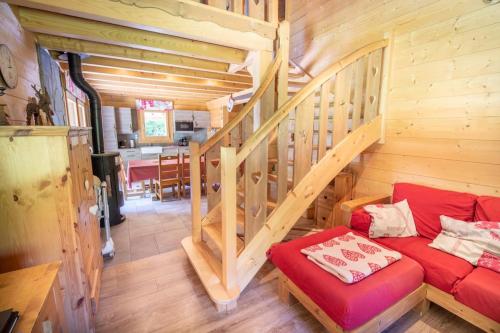 - un salon avec un canapé rouge dans une cabine dans l'établissement Chalet Cafourotte, au calme, SPA, à Gérardmer