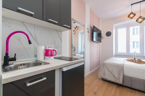 a kitchen with a sink and a bed in a room at Apartments & rooms SIX in Rijeka
