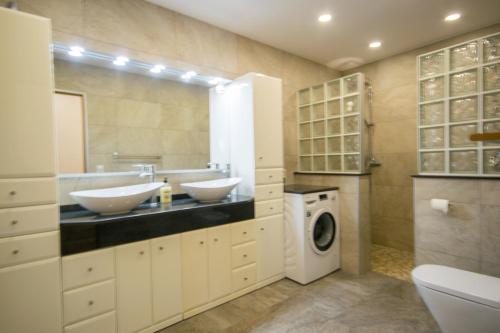 uma casa de banho com 2 lavatórios e uma máquina de lavar roupa em Villa Janina em Fuengirola
