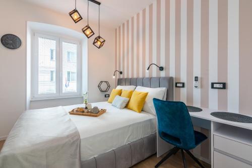 a bedroom with a bed with a desk and a blue chair at Apartments & rooms SIX in Rijeka