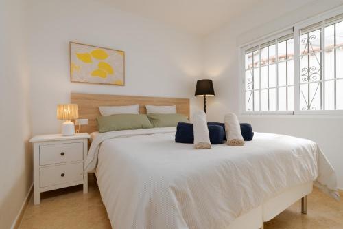 Un dormitorio con una gran cama blanca y una ventana en Casa Andasol, en Marbella