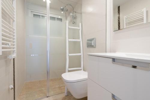 a white bathroom with a toilet and a shower at Casa Andasol in Marbella