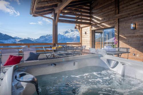a hot tub in a room with a view of mountains at Chalet Paralpin - OVO Network in Manigod