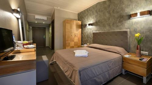 ポトスにあるAtrium Hotel Thassosのベッドルーム(大型ベッド1台、テレビ付)