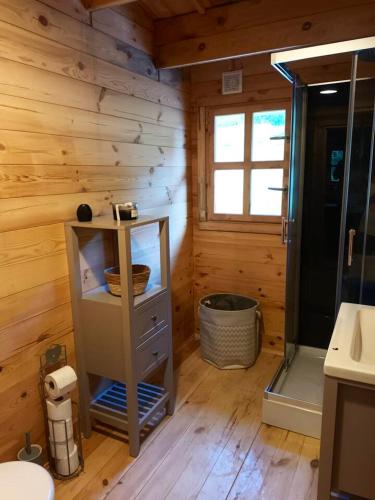 - une salle de bains dans une cabane en rondins avec un lavabo et une douche dans l'établissement Maison charmante à Fougax-et-Barrineuf, à Fougax-et-Barrineuf