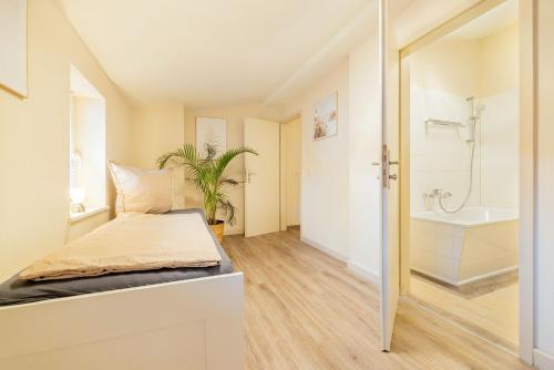 a bedroom with a bed and a bathroom with a tub at Ferienappartements Stralsund in Stralsund