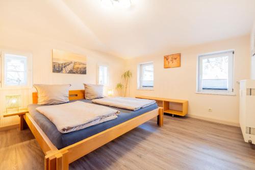 a bedroom with a bed and two windows at Ferienapartments Stralsund in Stralsund