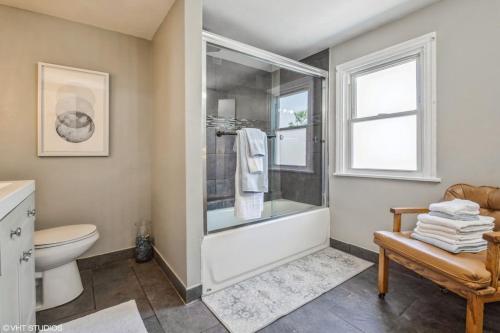 een badkamer met een bad, een toilet en een raam bij A terrific house for a large group. in Chicago
