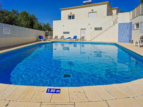 a swimming pool in front of a house at Villa ENCOSTA VISTA SALGADOS - BY BEDZY in Guia