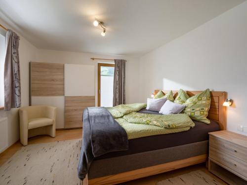 a bedroom with a large bed and a chair at Appartement Elisabeth in Ramsau im Zillertal