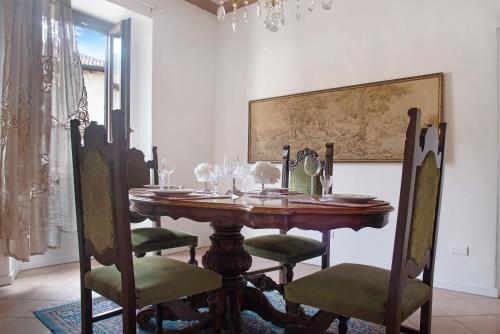 a dining room with a wooden table and chairs at Dimora Ettore - Lago Maggiore in Casalzuigno
