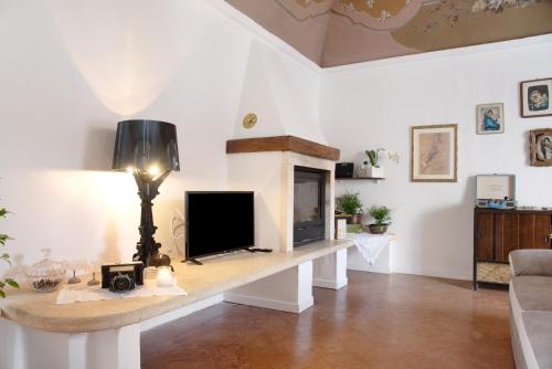 a living room with a tv and a fireplace at Dimora Ettore - Lago Maggiore in Casalzuigno