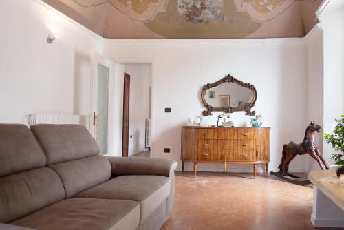 a living room with a couch and a mirror at Dimora Ettore - Lago Maggiore in Casalzuigno