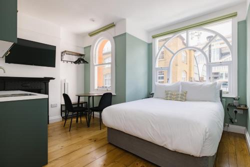 a bedroom with a bed and a kitchen with a table at CitySpace Kings Cross in London