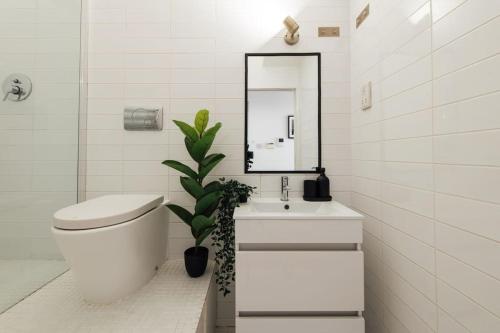 a bathroom with a toilet and a sink and a mirror at Unique 2 Bedroom Flat on Stoke Newington High Street in London