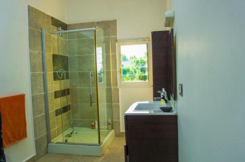 La salle de bains est pourvue d'une douche et d'un lavabo. dans l'établissement Room in Villa - The white-orange bedroom with a pleasant view overlooking the lake, à Antananarivo