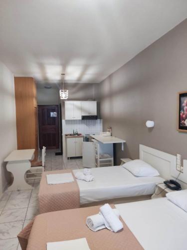 a large room with two beds and a kitchen at Karaoulanis Beach in Agios Ioannis Pelio