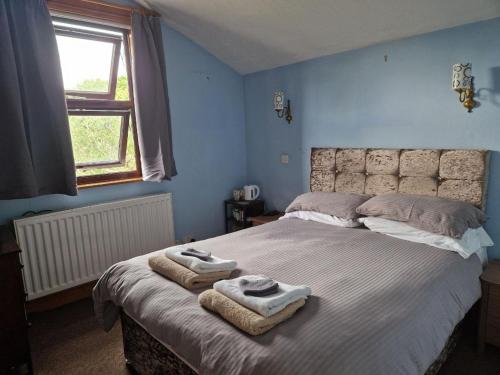 a bedroom with a large bed with towels on it at The Guest House in Sheringham in Sheringham