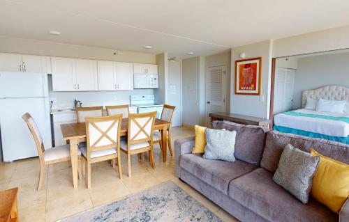 a living room with a couch and a table and a kitchen at One-Bedroom Apartment in Honolulu