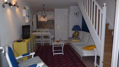 a small living room with a white couch and stairs at Joli Pavillon 2** Narbonne Plage in Narbonne-Plage