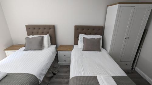 two beds sitting next to each other in a room at Cocoon @ International Inn + Apartments in Liverpool
