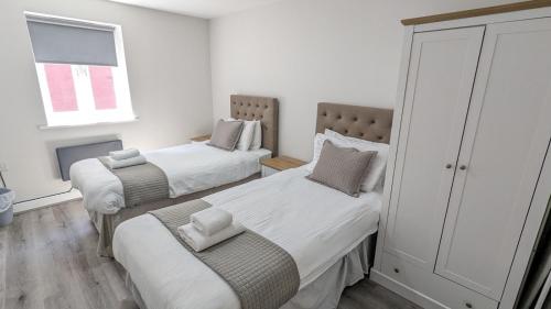 1 dormitorio con 2 camas y ventana en Cocoon @ International Inn + Apartments, en Liverpool