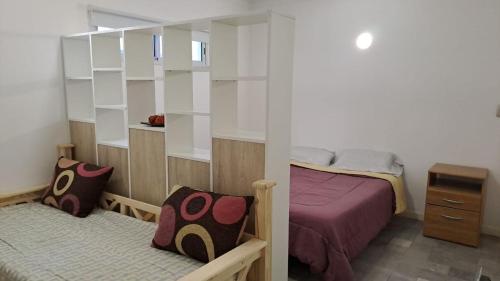 una piccola camera da letto con un letto e uno specchio di Terraza quincho y jacuzzi privados 4 personas a Mar del Plata