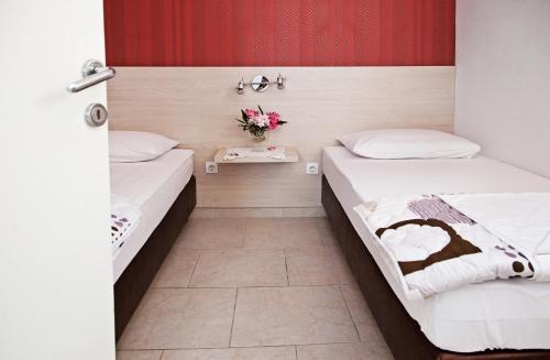 a room with two beds and a vase of flowers at Holiday Park Mandrice in Mandre