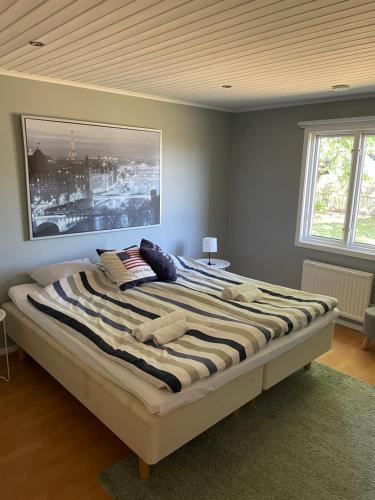1 dormitorio con 1 cama grande y una pintura en la pared en Trevligt hus i mysiga Mollösund Tången, en Mollösund