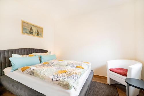 een slaapkamer met een bed en een stoel bij Ferienwohnungen Bernstein in Stralsund