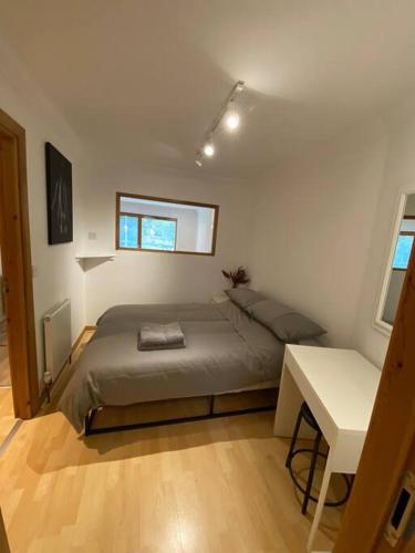 a small bedroom with a bed and a desk at Apt 2 Cathedral & River view in Norwich